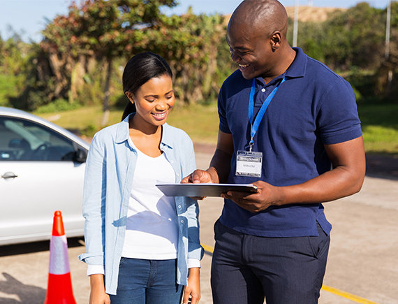 Driving instructor showing student clip board.